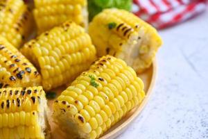 Zuckermais gekocht auf Holzplattenhintergrund, reife Maiskolben gegrillter Zuckermais für veganes Abendessen oder Snack, Maisnahrung foto