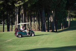 Paar im Buggy auf dem Golfplatz foto