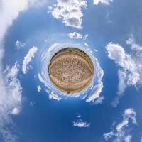 Winzige Planetentransformation des sphärischen Panoramas 360 Grad. sphärische abstrakte luftaufnahme im feld mit klarem himmel und fantastischen schönen wolken. Krümmung des Raumes. foto