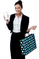 Dame hält Kaffeetasse und Einkaufstasche foto