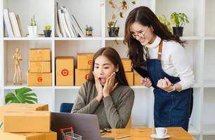 Produkte an Inhaber von Online-Geschäften verkaufen. Zwei Frauen, die Freude am Online-Verkauf zeigen, übertrafen die Erwartungen. foto