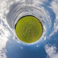 grüner winziger planet im blauen himmel mit schönen wolken. Transformation des sphärischen Panoramas 360 Grad. sphärische abstrakte Luftaufnahme. Krümmung des Raumes. foto