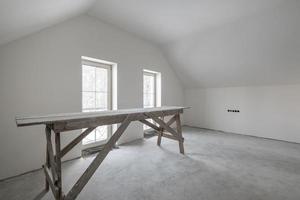 leerer weißer Raum mit Mansarde ohne Reparatur und Möbel mit Gerüst foto