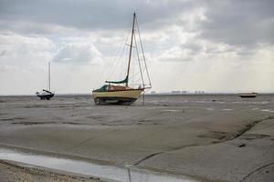 Fischerboote stecken bei Ebbe am Strand fest. foto