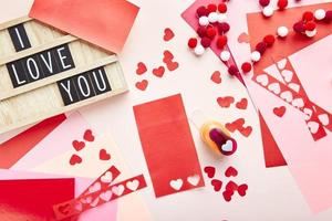 Valentinstag Hintergrund. Papierherzen, farbiges Papier, Papierschneider und Letterboard mit Text foto