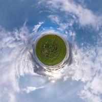 grüner winziger planet im blauen himmel mit schönen wolken. Transformation des sphärischen Panoramas 360 Grad. sphärische abstrakte Luftaufnahme. Krümmung des Raumes. foto