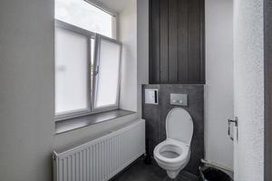 Toilette und Detail einer Eckduschkabine mit wandmontierter Duschvorrichtung foto