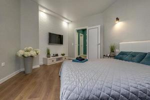 Interieur des modernen Luxus-Schlafzimmers in Studio-Apartments in grauem, hellem Farbstil und grünen Kissen