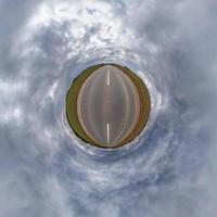 kleiner Planet im blauen Himmel mit schönen Wolken. Transformation des sphärischen Panoramas 360 Grad. sphärische abstrakte Luftaufnahme. Krümmung des Raumes. foto