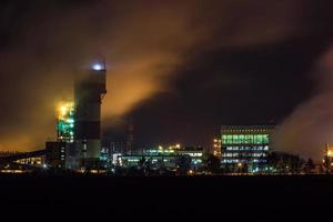 nacht industrielandschaft umweltverschmutzung abfall des wärmekraftwerks. große rohre der unternehmensanlage der chemischen industrie foto