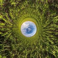 Ball des blauen Himmels unter grünem Gras. Umkehrung der winzigen Planetentransformation des sphärischen Panoramas 360 Grad. sphärische abstrakte Ansicht. Krümmung des Raumes. foto