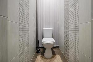 Toilette und Detail einer Eckduschkabine mit wandmontierter Duschvorrichtung foto