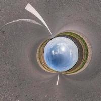 Blauer Himmelsball inmitten einer wirbelnden Asphaltstraße. Umkehrung der winzigen Planetentransformation des sphärischen Panoramas 360 Grad. sphärische abstrakte Ansicht. Krümmung des Raumes. foto