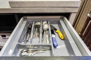 Satz Messer, Gabeln und Löffel auf dem Regal im Küchenschrank foto