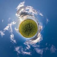 kleiner Planet im blauen Himmel mit Sonne und schönen Wolken. Transformation des sphärischen Panoramas 360 Grad. sphärische abstrakte Luftaufnahme. Krümmung des Raumes. foto