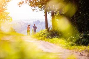 junges paar joggen an einem sonnigen tag in der natur foto