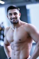 gutaussehender Mann, der im Fitnessstudio trainiert foto