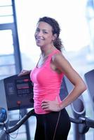 Frau trainiert auf dem Laufband im Fitnessstudio foto