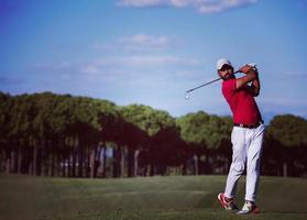 Golfspieler, der einen langen Schuss schlägt foto