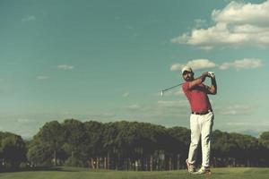 Golfspieler, der einen langen Schuss schlägt foto