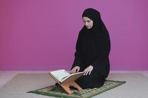nahöstliche frau, die den heiligen koran betet und liest foto