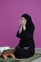 nahöstliche frau, die den heiligen koran betet und liest foto