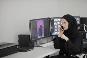 muslimische grafikdesignerin, die am telefon spricht foto