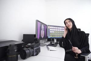 muslimische grafikdesignerin, die am telefon spricht foto