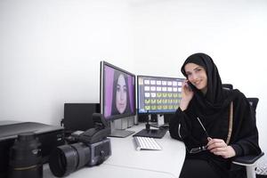 muslimische grafikdesignerin, die am telefon spricht foto