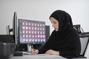 muslimische grafikdesignerin, die am computer arbeitet foto