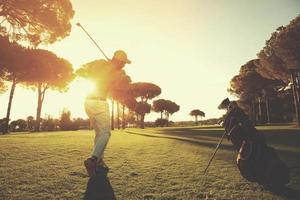 Golfspieler, der mit Schläger schlägt foto