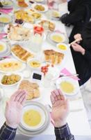 traditionelle muslimische familie, die vor dem iftar-abendessen betet foto