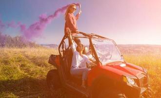 Gruppe junger Leute, die sich beim Fahren eines Offroad-Buggy-Autos amüsieren foto