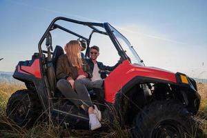 Ein Paar genießt einen schönen sonnigen Tag, während es einen Offroad-Buggy fährt foto