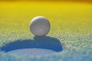 Golfball auf der Lippe der Tasse foto