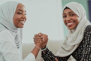 afrikanisches armwrestling-konfliktkonzept, uneinigkeit und konfrontation in traditioneller islamischer hijab-kleidung. selektiver Fokus foto