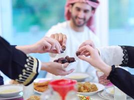 muslimische familie beim iftar-abendessen, das datteln isst, um das fest zu brechen foto