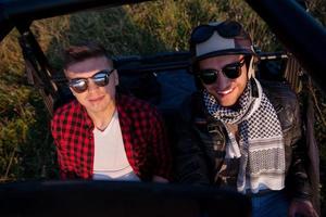 Zwei junge Männer, die ein Offroad-Buggy-Auto fahren foto