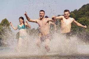 gruppe glücklicher freunde, die spaß am fluss haben foto