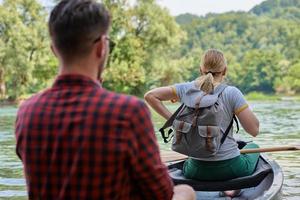 Freunde fahren in einem wilden Fluss Kanu foto