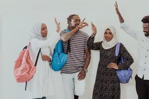 Foto einer Gruppe glücklicher afrikanischer Studenten, die miteinander reden und sich treffen, um an Hausaufgaben zu arbeiten, Mädchen, die traditionellen sudanesischen muslimischen Hijab tragen