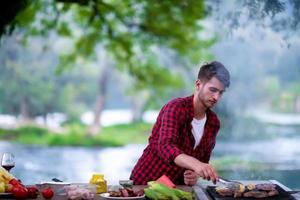 Mann, der leckeres Essen auf dem Grill kocht foto