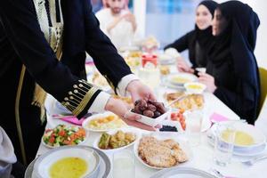 muslimische familie beim iftar-abendessen, das datteln isst, um das fest zu brechen foto