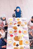 Draufsicht der modernen multiethnischen muslimischen Familie, die auf den Beginn des Iftar-Abendessens wartet foto