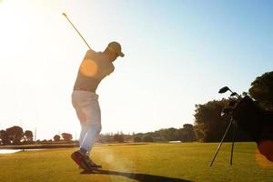 Golfspieler, der mit Schläger schlägt foto