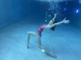 lächelndes Kind mit Brille schwimmen, mit Spaß im Pool tauchen - tief unter Wasser springen. gesunder lebensstil, menschen wassersportaktivitäten im sommer. foto