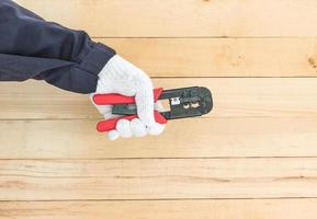 Hand im Handschuh halten Abisolierzange foto