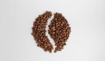 Kaffeebohnen. isoliert auf einem grauen Hintergrund in Form einer Kaffeebohne foto