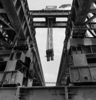 Schwarz-Weiß-Foto der Stahlkonstruktion einer Trägerrakete, die für die Errichtung von Betonfertigteilen verwendet wird, die ich über den Fluss spanne. Diese gelbe Gantry stammt aus Indonesien. foto