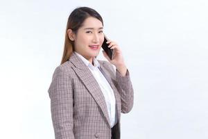 asiatische geschäftsfrau im formellen anzug mit weißem hemd ruft telefon an, um daten zu überprüfen. im formellen anzug mit weißem hemd telefoniert foto